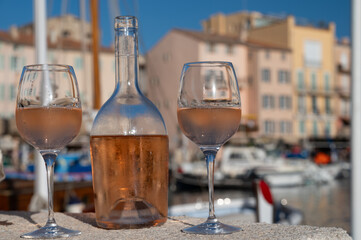 Glasses of cold rose Cote de Provence wine in old fisherman boats and yacht harbour in Saint-Tropez, summer vacation on French Riviera in Provence, France