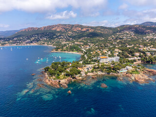 Fototapeta premium Panoramic view from above on blue Mediterranean dea, sandy beach of Agay town, summer vacation destination near Esterel mountains, French Riviera, Provence. France