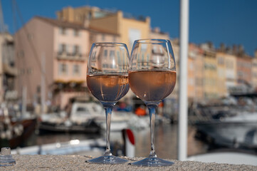 Glasses of cold rose Cote de Provence wine in old fisherman boats and yacht harbour in Saint-Tropez, summer vacation on French Riviera in Provence, France