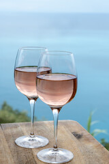 Summer time in Provence, two glasses of cold rose wine with blue sea view on background, French Riviera near Menton, south of France