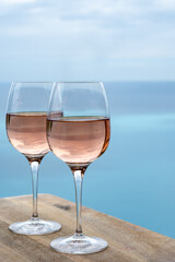 Summer time in Provence, two glasses of cold rose wine with blue sea view on background, French Riviera near Menton, south of France