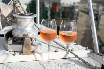Party with rose wine on yacht boat anchored in port la Rague, Gulf of La Napoule, in Provence, two glasses of cold rose wine, French Riviera near Cannes, south of France