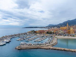 Naklejka premium Aerial view on French Riviera, colorful Menton old city and marina on Mediterranean Sea near French-Italian border, travel destination, panoramic view from above