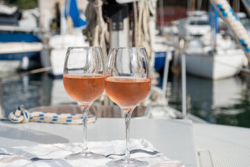 Party with rose wine on yacht boat anchored in port la Rague, Gulf of La Napoule, in Provence, two glasses of cold rose wine, French Riviera near Cannes, south of France