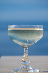 Cold sparkling wine, cava or champagne in coupe glass on table with blue sea water view, French Riviera is summer, France