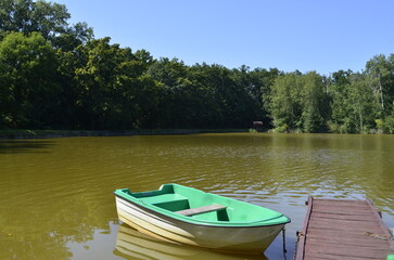 Obraz premium small boat standing near a wooden pier boat pier river