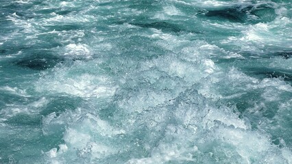 Dynamic seascape. Vibrant turquoise sea swirling with foamy waves, high speed motion of a mega yacht