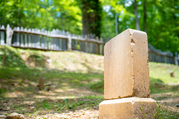 tombstone in a fenced grassy area