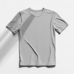 Fototapeta premium A gray t-shirt with a crew neck and short sleeves laid flat on a white background, with a shadow cast upon it.