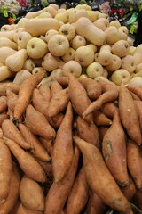 potatoes at the market,A pile of sweet potatoes and sweet potatoes for sale at a local vegetable market