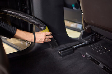 Professional car interior vacuuming with handheld vacuum for thorough cleaning and maintenance
