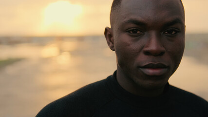 Portrait of young man outdoors by the sea in the evening, active lifestyle, sports motivation