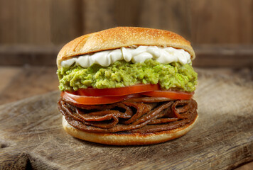 CHILEAN FOOD. Sandwich Churrasco italiano on colors of italian flag. Popular sandwich with round bread, beef, avocado guacamole, tomatoes and mayonnaise