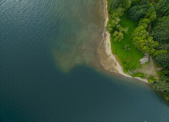 A body of water with a sandy beach and trees in the background