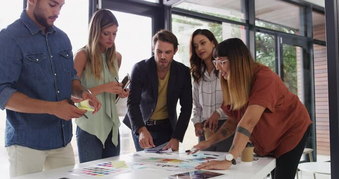 Designer, group and office for color sample, talk and choice with writing notes on tablet. Men, women and graphic design for planning, creative or collaboration for brainstorming in startup agency