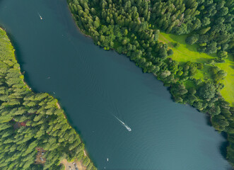 A boat is floating on a lake with trees in the background