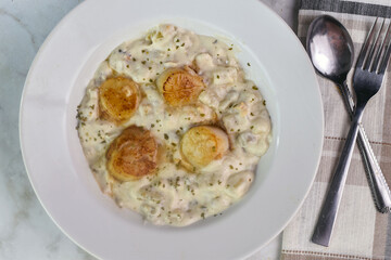 clam chowder top  with herbs and scallops