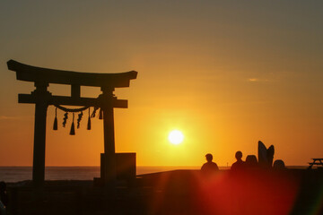 鳥居のある砂浜で仲間と日の出
