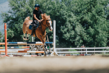 Focused rider and horse executing a high jump during an outdoor equestrian event on a sunny day,...