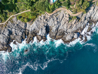 Vista aérea impresionante de una costa rocosa con olas rompiendo en las rocas, rodeada de...