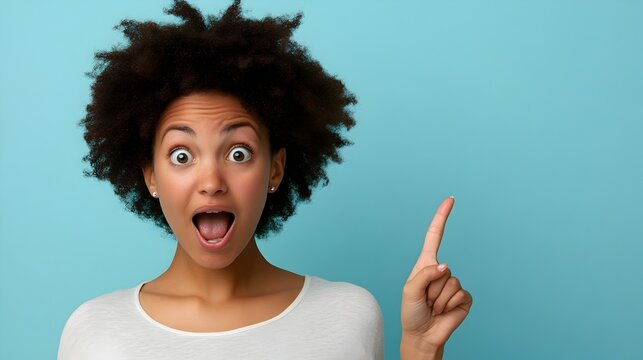 Portrait of a surprised and amazed man pointing to the side with a shocked astounded expression on an isolated studio background  The person is showing a powerful emotional reaction and gesture
