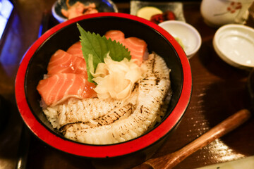 close up of Japanese raw seared salmon Flounder Sashimi fish rice in a black and red bowl donburi with ginger