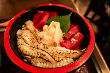 close up of Japanese raw sashimi fish tuna flatfish rice donburi in a red and black bowl