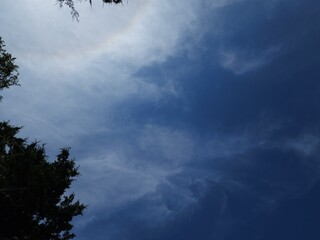inverted rainbow behind slight cloud cover