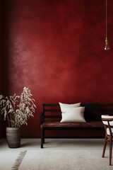 A minimalist living room with a red textured wall, a wooden bench with white and black cushions, and a potted plant.