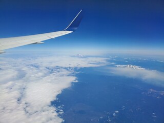 Airplane Flying With A Tall Mountain In Sight