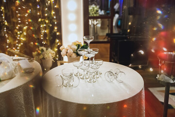 Pyramid of glasses for champagne at outdoor garden in wedding ceremony. Lifestyle, background.