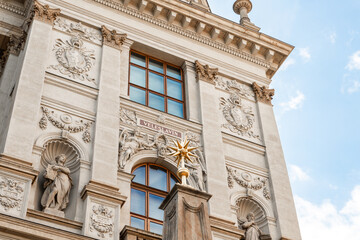 Prague, Czech Republic, May 12, 2024 : Gilded star on top of pillar in front of facade of Peoples Museum on famous Wenceslas Square in Prague in Czech Republic