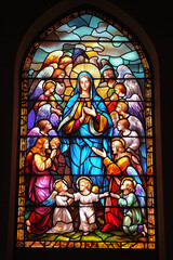 Beautiful stained glass window depicting the Madonna surrounded by angels with serene expressions, bathed in vibrant colors and intricate patterns, capturing divine serenity.