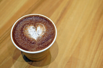 A cup of hot chocolate with painted hearts in a white cup on a wooden background, Coffee time concept, Coffee break time.