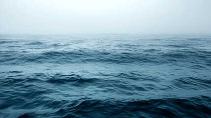 Fototapeta premium Serene lake shrouded in mist at dawn, reflecting the calm water and distant horizon. Ideal for themes of tranquility, introspection, and natural beauty