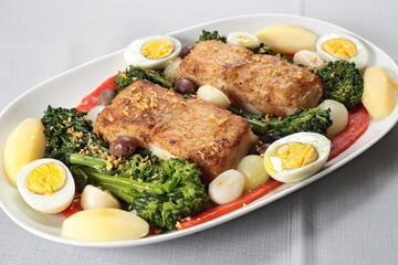 Portuguese cod with eggs, broccoli and peppers on a plate