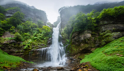 A turbulent waterfall cascading down a rocky cliff,