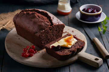 a chocolate bread loaf being served on a wooden board