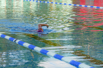 A competitive swimmer swims in a pool during training.