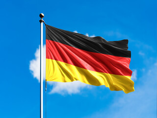 Germany flag flying on blur blue clouds background.