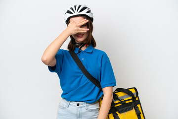 Young Ukrainian woman with thermal backpack isolated on white background covering eyes by hands and smiling