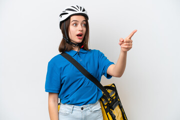 Young Ukrainian woman with thermal backpack isolated on white background pointing away