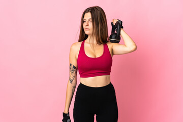 Young slovak woman isolated on pink background making weightlifting with kettlebell