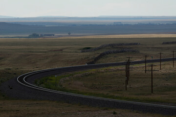 A curved train track in a vast prarie