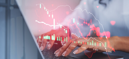Businesswoman using laptop, financial graph falling and stock market crisis