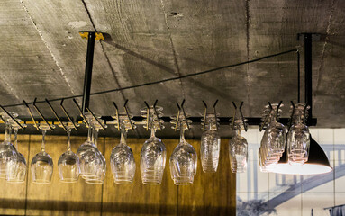 Wineglasses hanging from the ceiling, wine bar, industrial style, modern