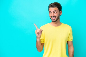 Fototapeta premium Young caucasian man isolated on blue background intending to realizes the solution while lifting a finger up
