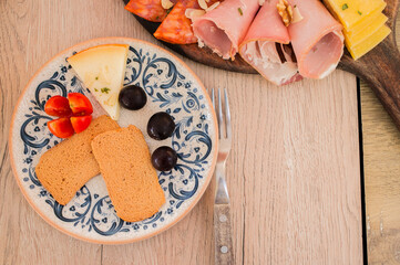 Portuguese charcuterie plate with ham, different cheeses and bread, directly above
