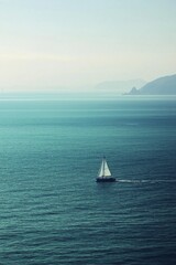 A small boat sailing on a vast ocean, with the distant coastline blurred out. 