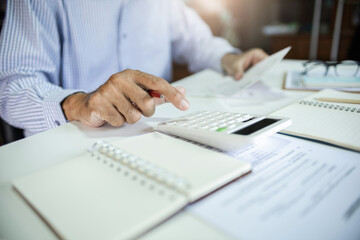 Close-up shot. asian men hand using calculator to calculate expenses and tax to recive tax reduction for personal individual Income. tax return concept for individual person